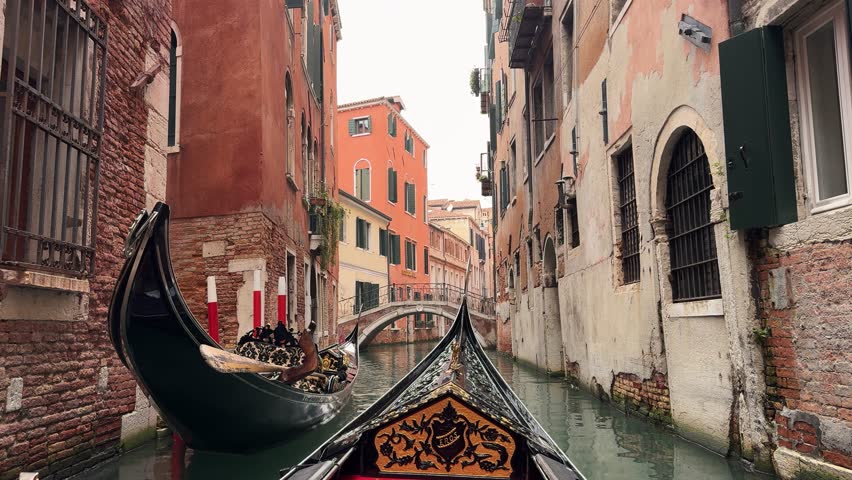 Italy, Venice, famous gondola ride through a typical narrow canal with small stone bridge inside the city. Relaxing moment with a first person view onboard camera. Royalty-Free Stock Footage #3501254901