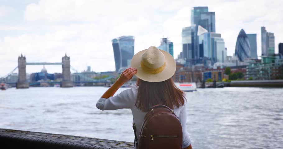 A tourist woman on a city vacation trip looks at the skyline of London, England