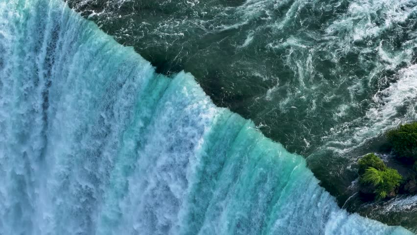 Niagara Falls on both the American and Canadian sides. Powerful waterfall of crystal clear waters. Majestic and misty rapids of the 56 km long Niagara River. Boat under the waterfalls with tourists.
