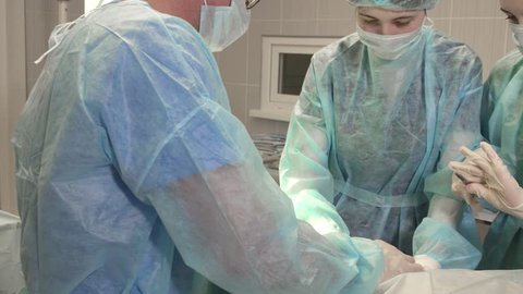 a nurse helps a surgeon during an operation