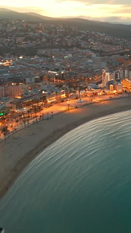 Aerial view of Peniscola beach and castle at twilight, Peniscola is a popular coastal town on Costa del Azahar, Province of Valencia, Spain. Drone night shot of medieval Spanish town