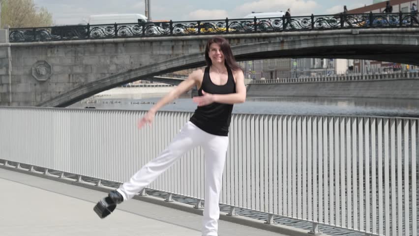 With boundless energy and a spirit of adventure, a woman leaps against a city backdrop, showcasing the exhilaration of urban exploration.