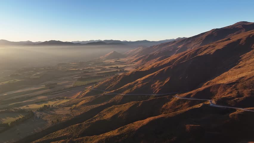 Spectacular sunset over mountain range, New Zealand landscape. Alpine highway to Cardrona, road trip.