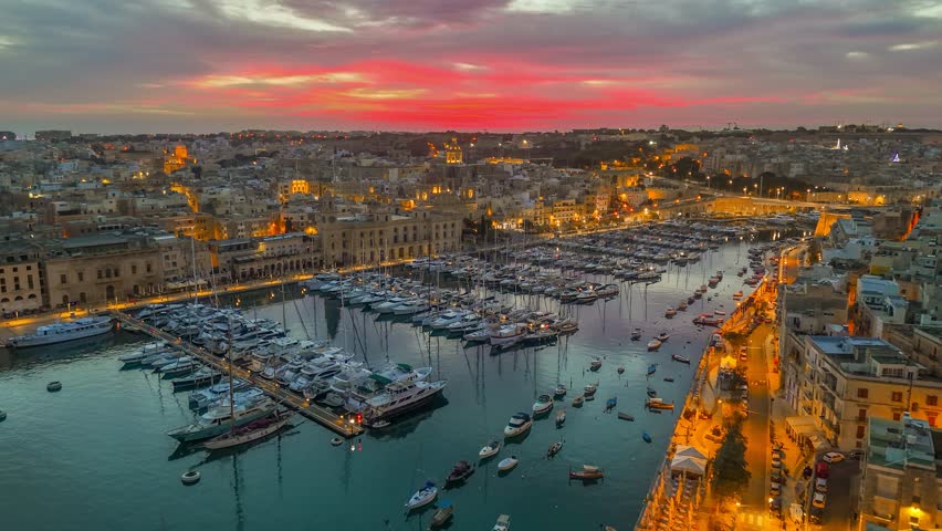 Aerial sunrise view of three cities - Vittoriosa, Senglea and Cospicua - Malta. Epic evening shot of old town with churches and marina with yacht in Malta 