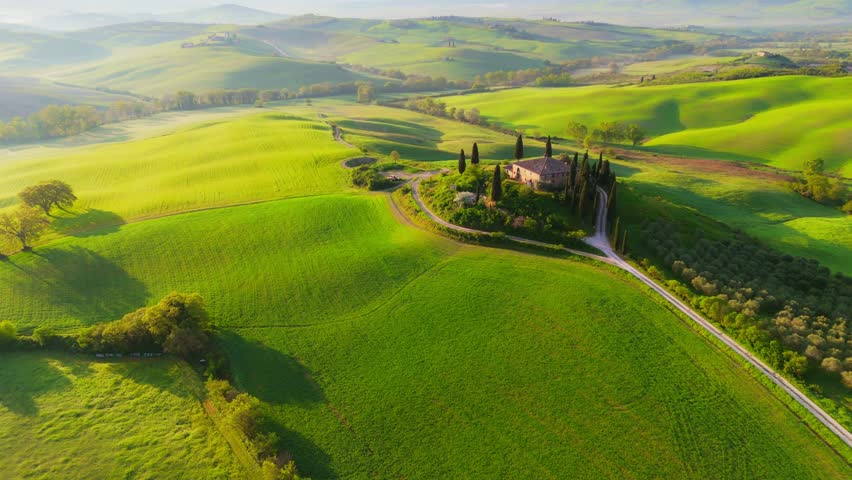 Spring time in Tuscany, Italy.  Aerial morning view of Tuscany countryside with green hills and field. Shot at sunrise, UHD, 4K