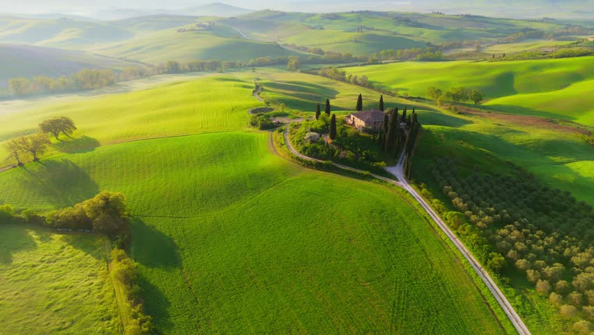 Spring time in Tuscany, Italy.  Aerial morning view of Tuscany countryside with green hills and field. Shot at sunrise, UHD, 4K