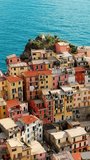 Aerial vertical video of colorful houses in Manarola village, Italy.
