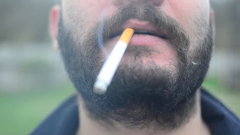 A man with beard is Smoking 
