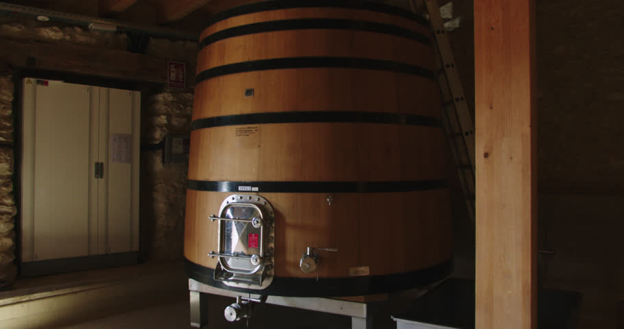 Slow motion shot of a large wooden barrel containing wine at temperature in a factory in Burgos, Spain