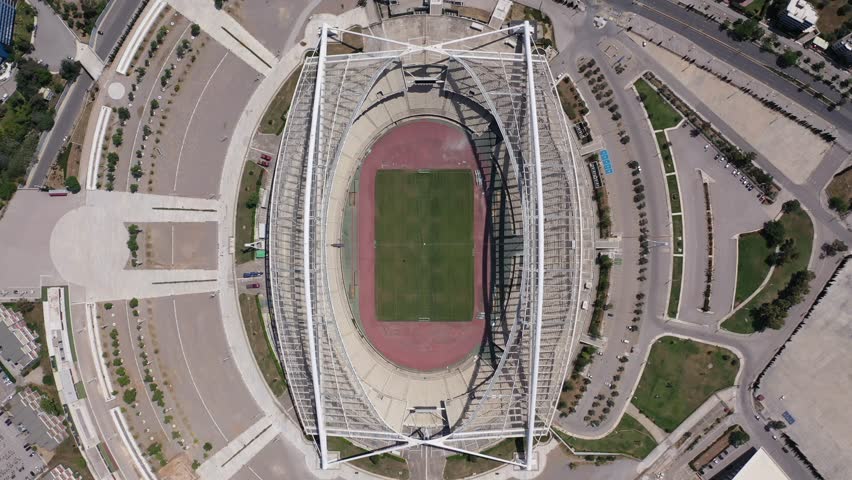 Aerial drone cinematic top down video of Olympic sports stadium and football pitch of OAKA designed by Santiago Calatrava, Kalogreza, Attica, Greece