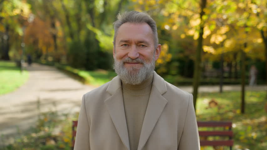 Outdoor male portrait happy joyful cheerful 60s old mature senior middle aged Caucasian man retired businessman looking camera smile single intelligent grandfather posing smiling in autumn park city