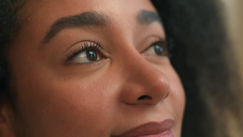 Close up pretty face African American ethnic woman young peaceful girl beautiful female looking up eyes purity meditating contemplating dreaming look in window smile natural beauty makeup health care