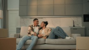 Happy African american family man woman home owners buy rent house repair apartment moving day relocation day unpacking furniture sofa delivery joyful affectionate couple love bonding on couch relax - Powered by Shutterstock - Get 15% off with code: PIKWIZARD15