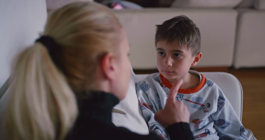 A mother is seen reprimanding her young son, who appears attentive and possibly remorseful, in the familiar environment of their home. Royalty-Free Stock Footage #3501584317