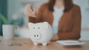 Young Asian woman putting coin in piggy bank. Save money and financial investment - Powered by Shutterstock - Get 15% off with code: PIKWIZARD15