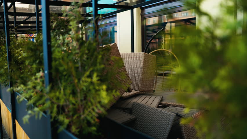 A patio with a table and chairs surrounded by plants