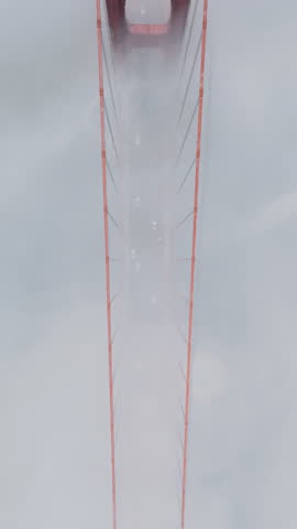 Vertical Screen: the Tower of the Golden Gate Bridge Emerges from the Fog, Creating a Mysterious and Ethereal Atmosphere Perfect for Cinematic Captures. 