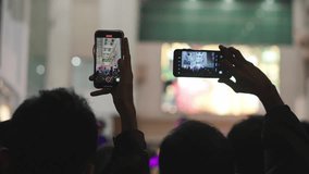 People crowd record music concert using mobile phones. 