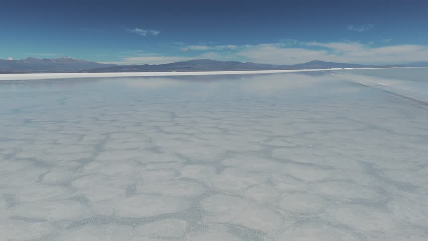 Drone shot flying over the water of the Salinas Grandes salt flat in Jujuy, Argentina. 4k