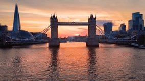 Boat perspective and aerial view towards the skyline and Tower Bridge of London, England, during a beautiful, orange sunset - Powered by Shutterstock - Get 15% off with code: PIKWIZARD15