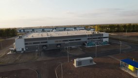 Exterior of warehouse features large doors and windows. Warehouse surrounded by car park with designated parking areas for trucks - Powered by Shutterstock - Get 15% off with code: PIKWIZARD15