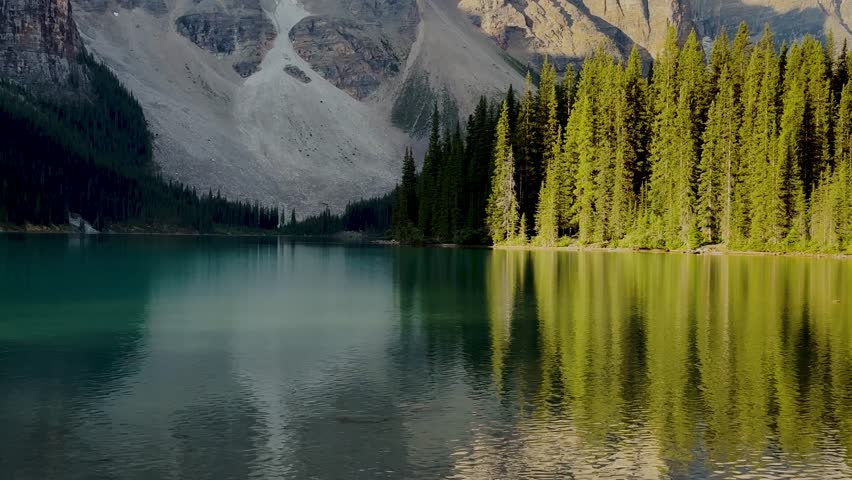 Moraine Lake is a Canadian glacial lake located in Banff National Park in Alberta. Sunrise at the lake. Moraine lake timelapse. Dense fir forests. Lakes in Canada. Extremely beautiful nature.
