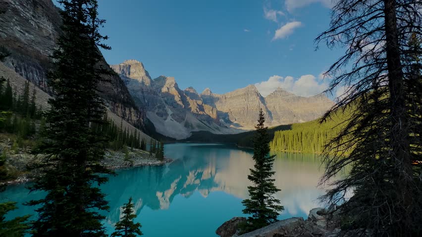 Moraine Lake is a Canadian glacial lake located in Banff National Park in Alberta. Sunrise at the lake. Moraine lake timelapse. Dense fir forests. Lakes in Canada. Extremely beautiful nature.
