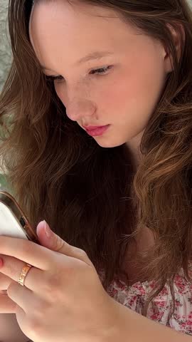 Girl with a mobile phone in a cafe Woman using app on smartphone smiling and texting on mobile phone.
