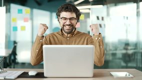 Happy excited businessman received great news on laptop while sitting at workplace in business office. Shocked surprised bearded man worker reads positive good message on computer, celebrates success - Powered by Shutterstock - Get 15% off with code: PIKWIZARD15