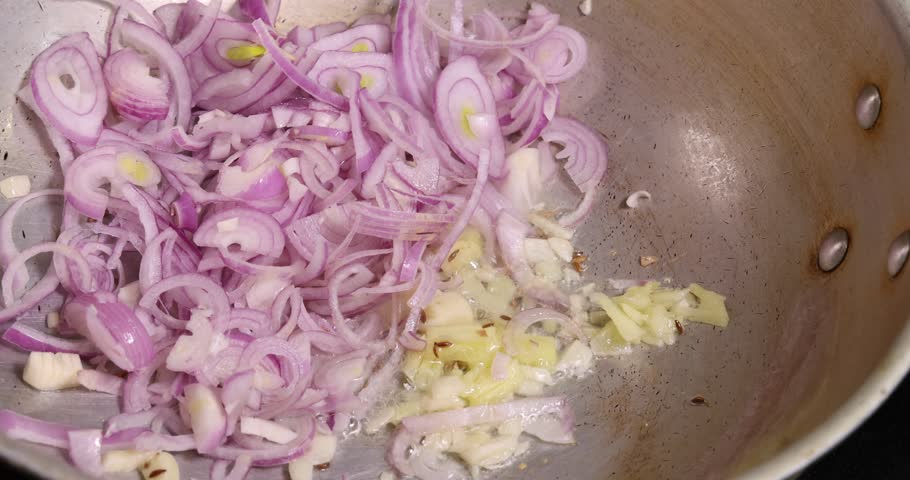Sauté frying tossing tomato onion garlic cumin red dry chilli spice in hot oil saucepan cooking for dal tadka bagar 