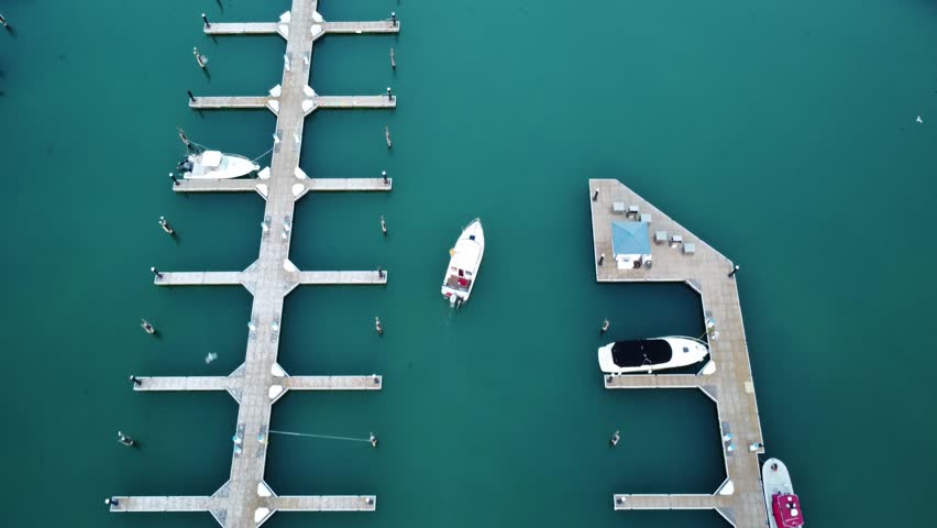 Aerial Drone Tracking A Small Boat (Yacht) Leaving The Marina Of Port Washington Harbor, Wisconsin, USA.