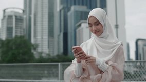 Young Pretty Woman Wearing Hijab Standing Outside and Using Smartphone, Reading Online Book. Stylish Muslim Lady in the Street Browsing in the Internet, Watching Videos in Social Media - Powered by Shutterstock - Get 15% off with code: PIKWIZARD15