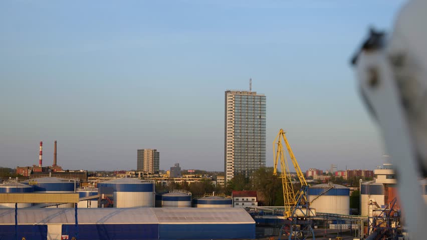 Pilsotas, the tallest multi-apartment building in the city of Klaipeda, stands near the port area. The building is illuminated by the sunset.