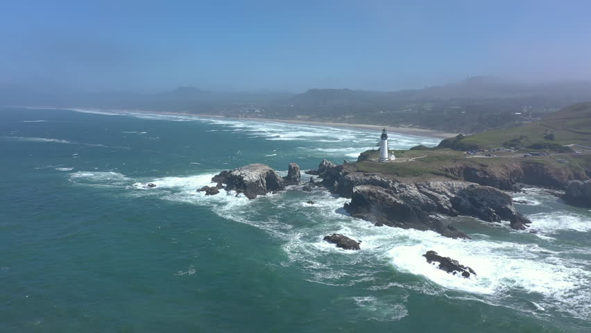 Yaquina Head Lighthouse Newport Oregon Coast. Wide drone orbit.