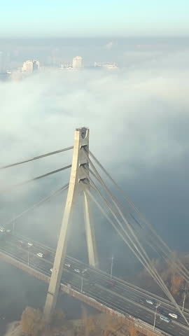 Aerial view of morning traffic on the North Bridge shrouded in fog in Kyiv, Ukraine. Vertical video.