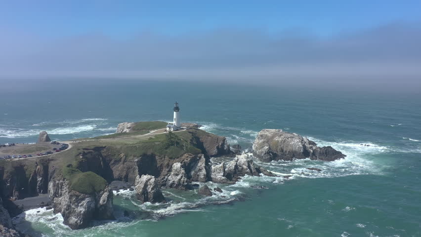 Yaquina Head Lighthouse Newport Oregon Coast.Drone backwards over ocean.