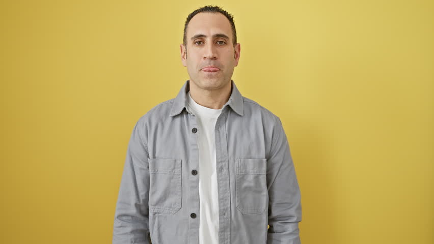 Life-styled hispanic guy in yellow, a positively radiant portrait of a young man wearing a shirt, smiling with confidence, and striking a cool pose with crossed arms.