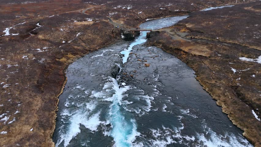 The vivid bruarfoss waterfall in iceland with icy waters and rocky terrain, winter season, aerial view Royalty-Free Stock Footage #3502301713