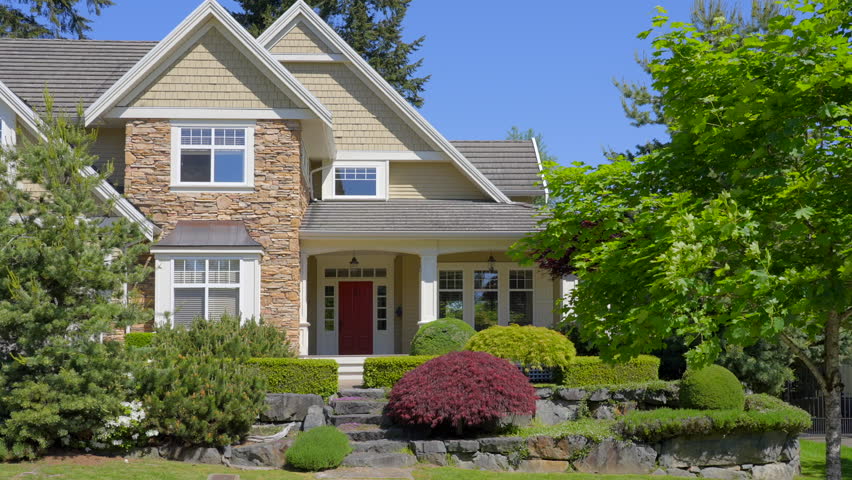 Establishing shot of two story stucco luxury house with nice summer  landscape in Vancouver, Canada, North America. Day time on May 2024. ProRes 422 HQ.