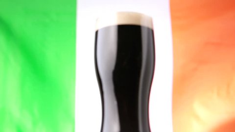 Pint of stout against irish flag blowing in the wind Stock Video