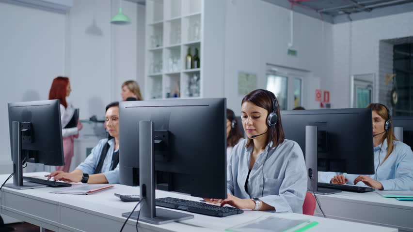 In Contact Center Of Bank Or Insurance Company, Women Workers With Headset Consulting Clients