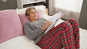 A relaxed woman reads a book in her bedroom, lying on the bed with plush pillows and modern decor. - Powered by Shutterstock - Get 15% off with code: PIKWIZARD15