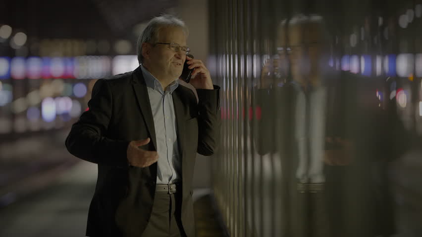 A whitecollar worker in formal wear and a blazer talking on a cell phone