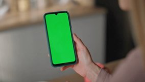 Girl browsing app chroma key smartphone making online order at home close up. Unrecognizable woman touching green screen cellphone on kitchen. Female fingers pointing on mockup mobile phone indoors. - Powered by Shutterstock - Get 15% off with code: PIKWIZARD15