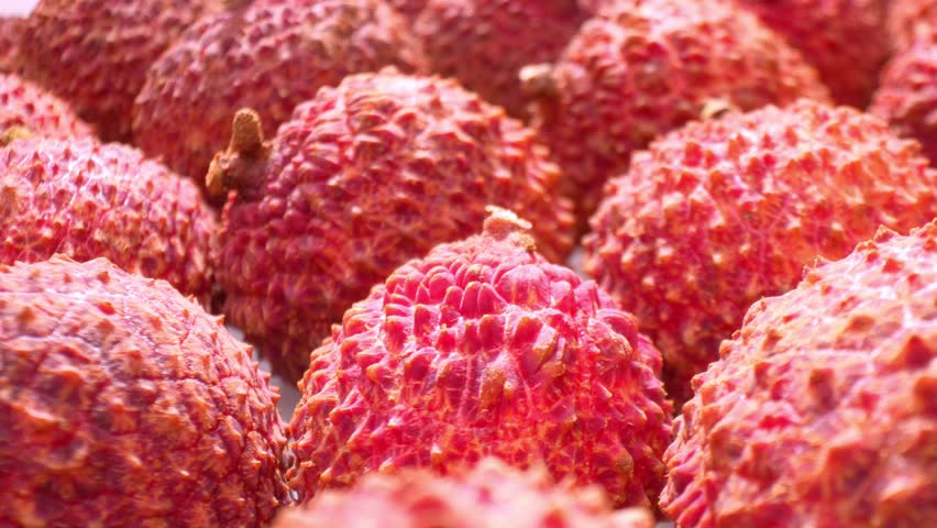 Get up close and personal with lychees as the camera zooms in on their rugged, reddish-brown skin. Every crevice and ridge unveils the fruit's exquisite texture, a testament to its natural beauty. 
