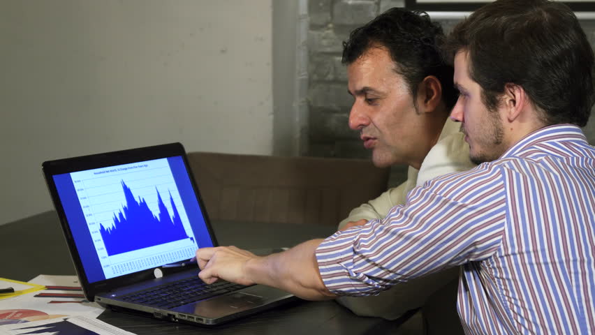 Two business colleagues discussing diagram on the laptop