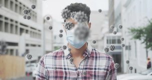 Animation of virus cells over biracial man wearing face mask. Global pandemic, healthcare, science and digital interface concept digitally generated video.