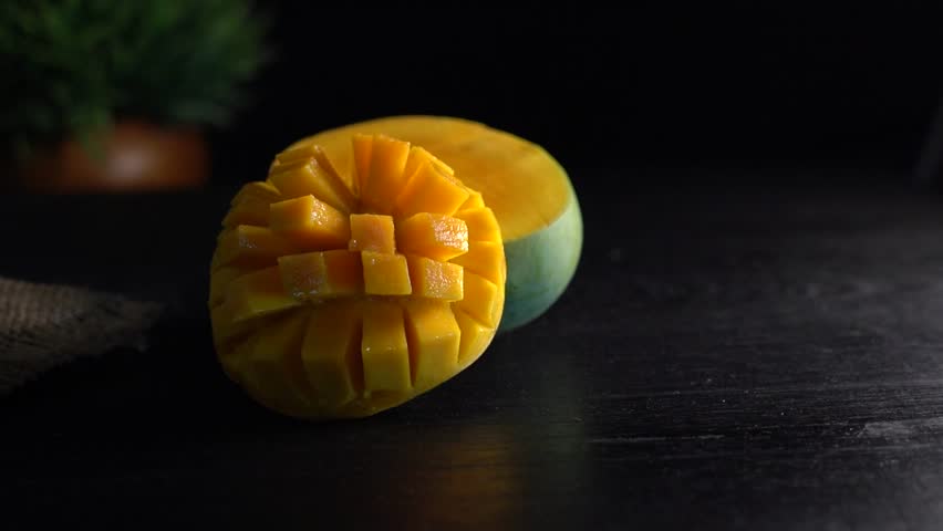 Mango Tropical Fruits On a Wooden background , Top view, copy space , set of mango cubes and mango slices isolated on a black background, Kerala delicious Whole mango fruit ,  Royalty-Free Stock Footage #3502522047