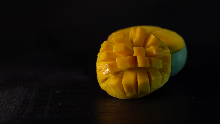 Mango Tropical Fruits On a Wooden background , Top view, copy space , set of mango cubes and mango slices isolated on a black background, Kerala delicious Whole mango fruit ,  Royalty-Free Stock Footage #3502522081