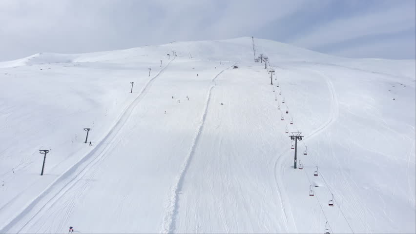 Drone view of skiers shredding the fresh snow while riding in the scenic mountains skiing downhill in the slopes at Mountain Kaimaktsalan Greece winter day